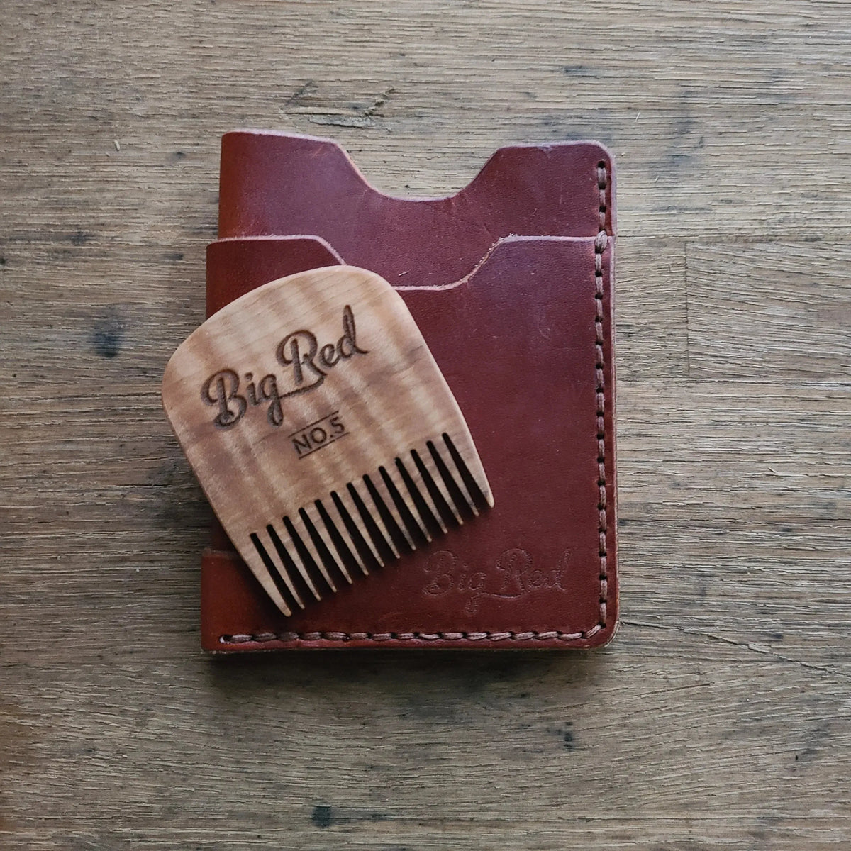 Big Red No. 5 beard comb with a leather wallet on a work bench
