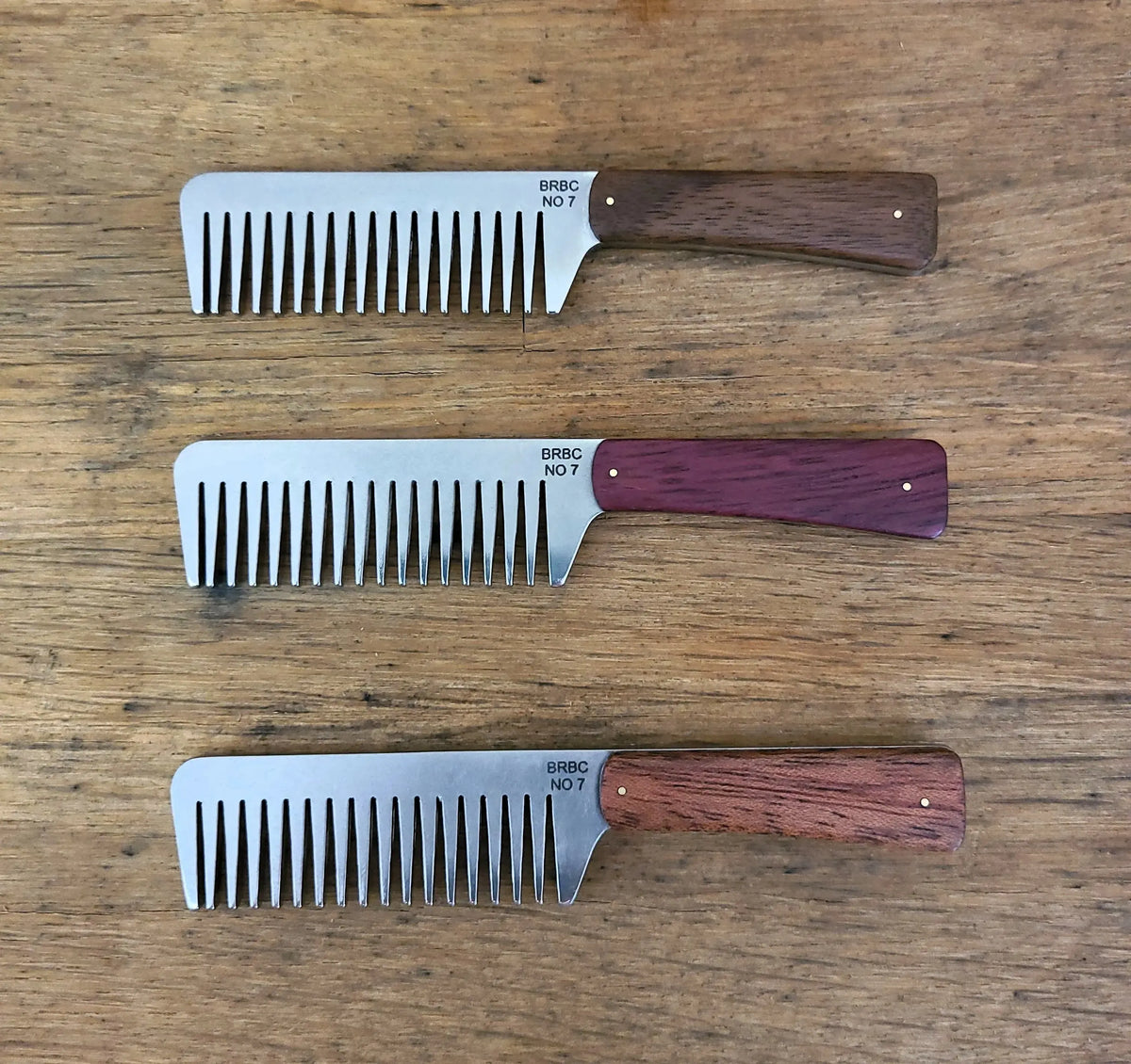 Big Red No. 7 stainless steel beard combs with walnut, purpleheart, and mahogany handles